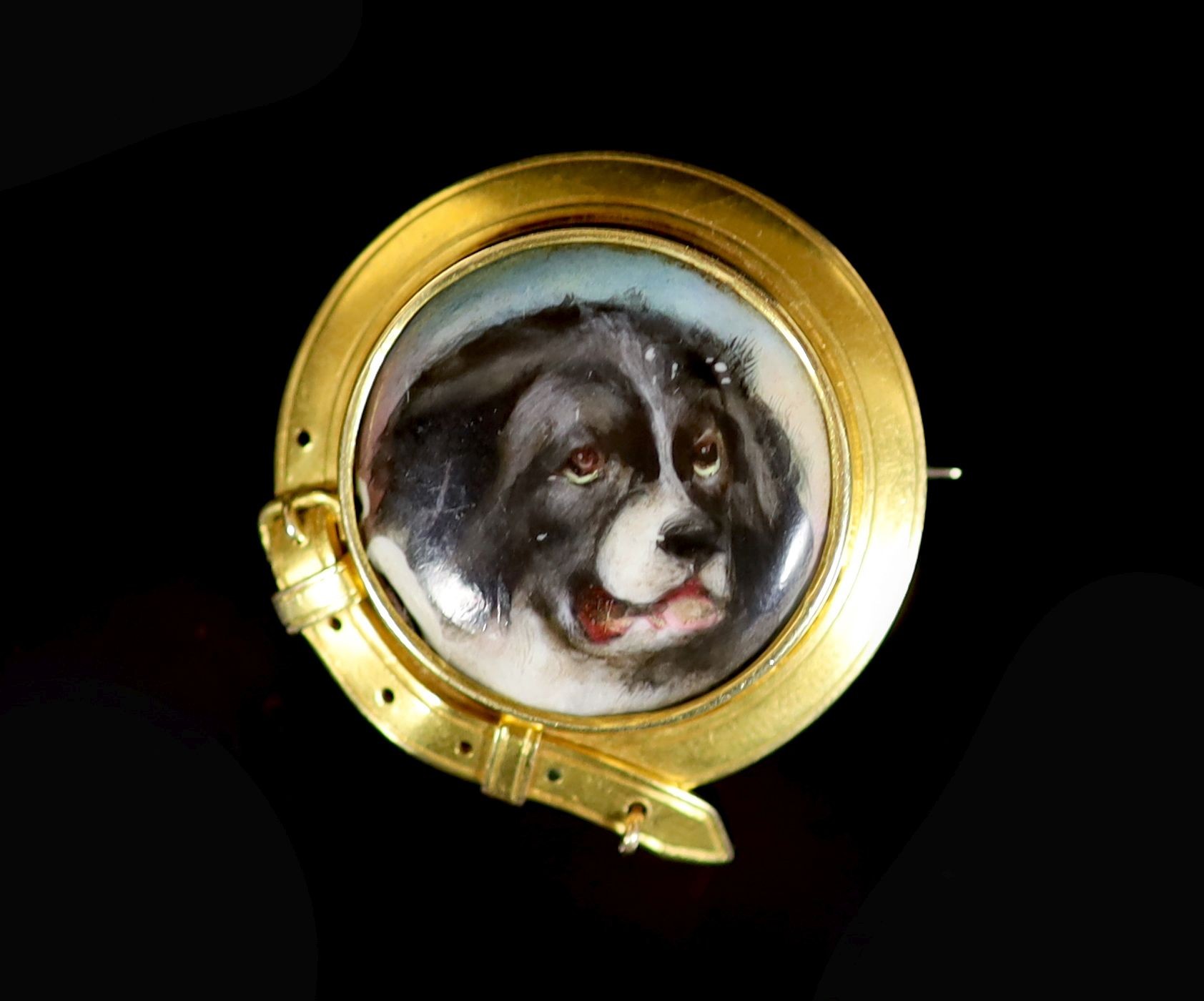 A Victorian gold and enamel circular brooch, decorated with the head of a dog, inscribed verso 'W. Essex, 1863'